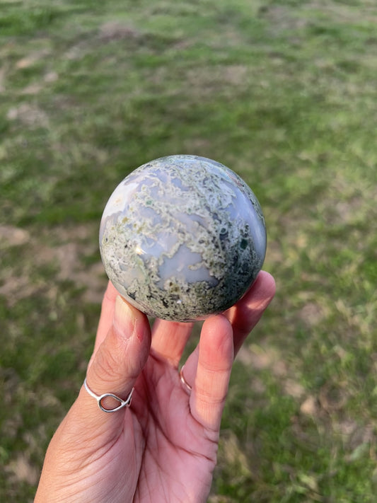 Natural green moss agate crystal sphere with earthy inclusions